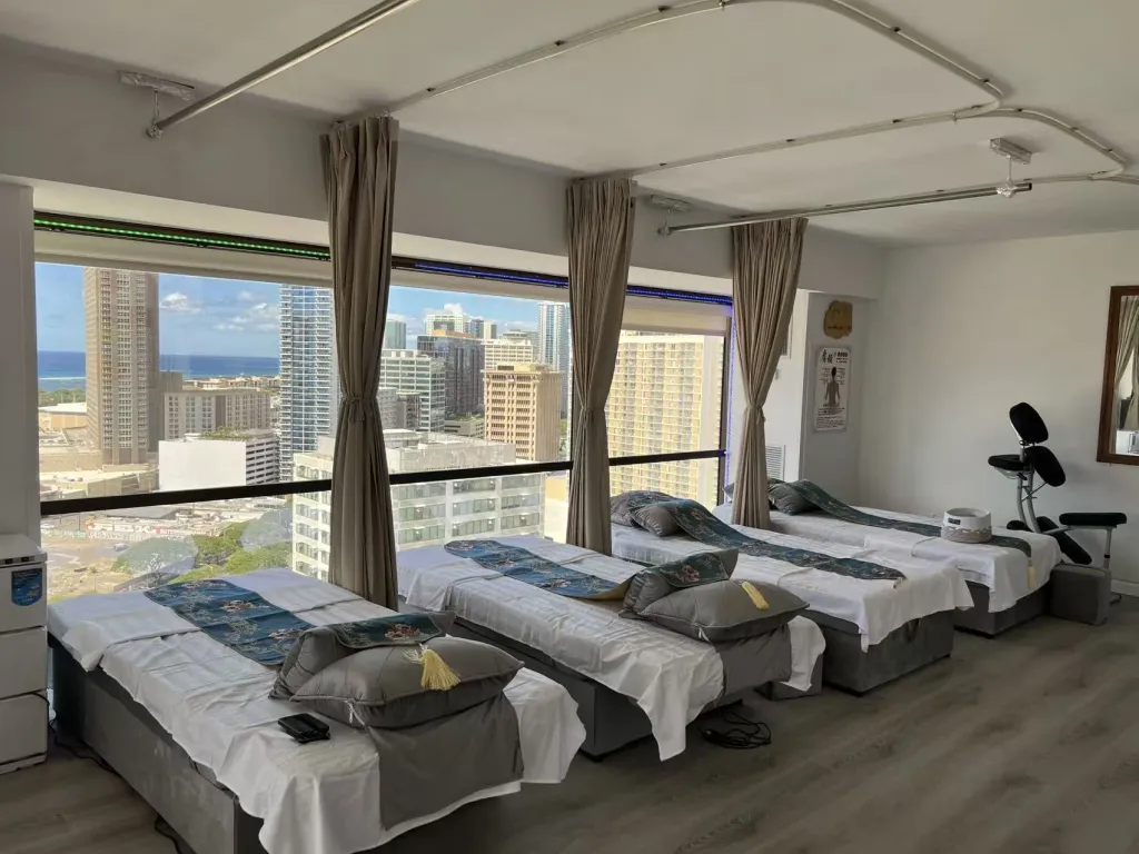 Ocean-view massage beds in a bright shared treatment room